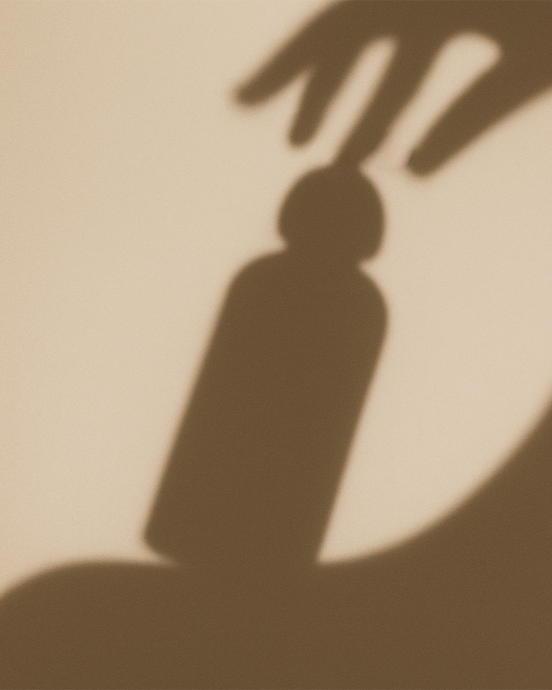 shadow of a Vitara herbal bath soak bottle on a woman's shoulder